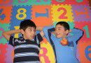 Boys lying on letter carpet