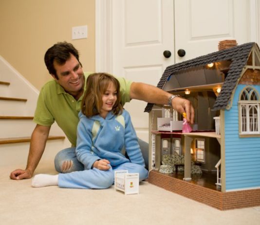 Dad and daughter play with doll house