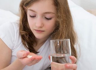 Girl taking pill in bedroom