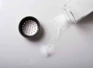 Salt poured from shaker onto table